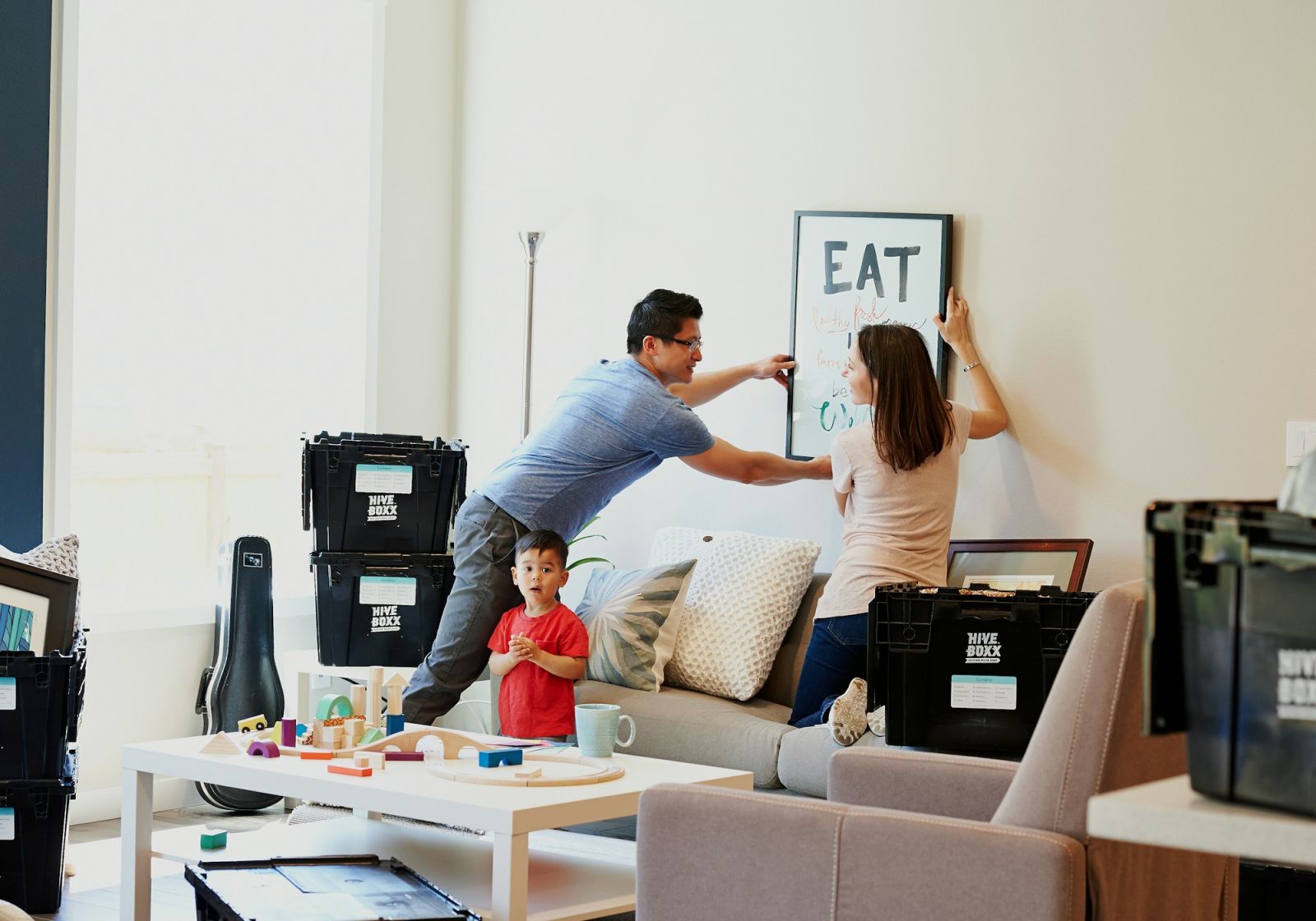 Familie richtet zwischen Umzugskisten die neue Wohnung ein