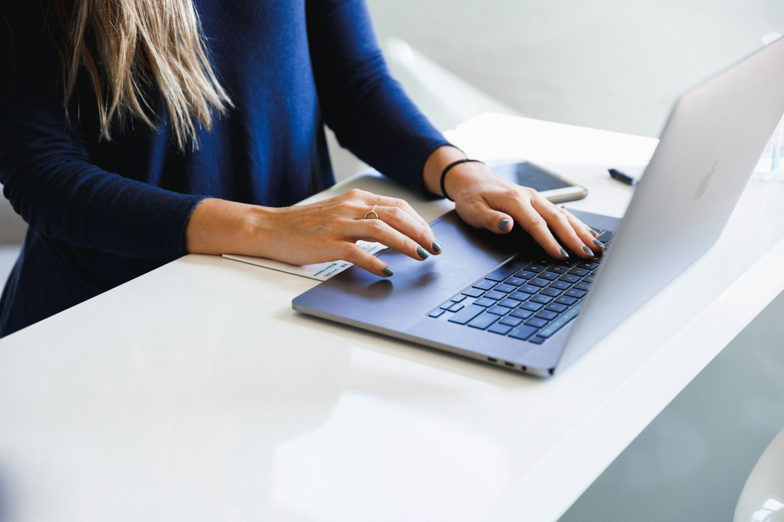 Maklerin arbeitet am Laptop an einem hellen Schreibtisch