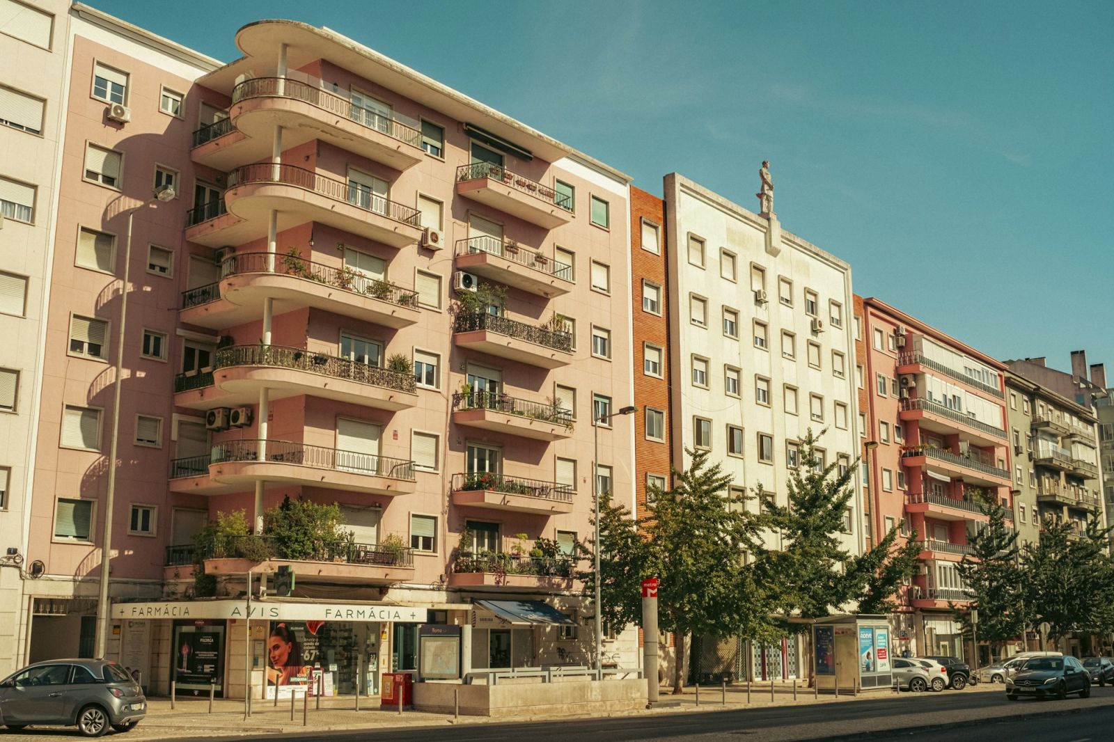 Straße mit Mehrfamilienhäusern und Balkonen in der Sonne
